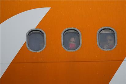 Aus den Vereinigten Staaten abgeschobene venezolanische Migranten schauen nach der Landung auf dem internationalen Flughafen Simon Bolivar in Maiquetia, Venezuela, aus den Bullaugen ihres Flugzeugs
