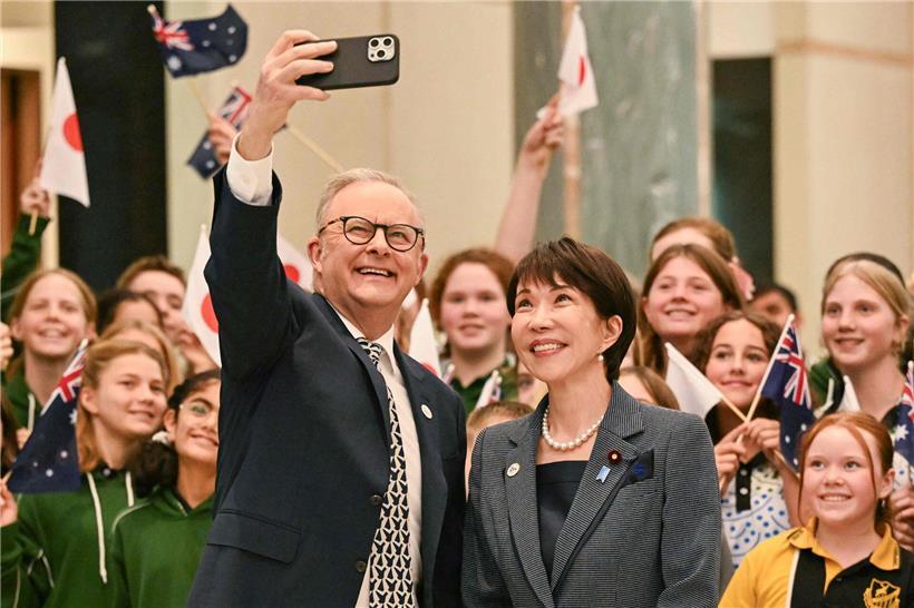 Australiens Premier Anthony Albanese und Japans Premierministerin Sanae Takaichi machen Selfie mit Schülerinnen bei internationalem Treffen