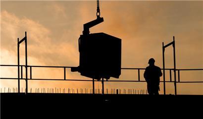 Bauarbeiter bauen bei Sonnenaufgang an einem Wohnhaus
