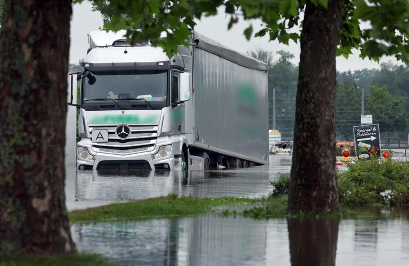 Bayern, Offingen: Ein Lastwagen steht am Montag im Hochwasser der Mindel auf einem Parkplatz
