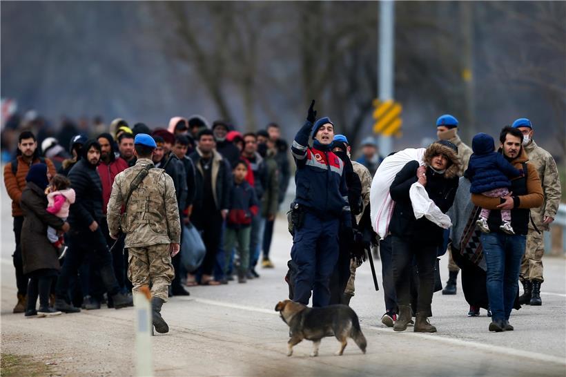 Beamte aus der Türkei geben Anweisungen, während sich die Migranten an der türkisch-griechischen Grenze versammeln. 
