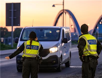 Beamte der Bundespolizei stehen am frühen Morgen bei der Einreisekontrolle
