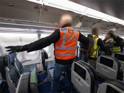 Beamte der deutschen Polizei und Mitarbeiter von Frontex begleiten einen Mann auf dem Flughafen Frankfurt auf einen Abschiebeflug nach Pakistan