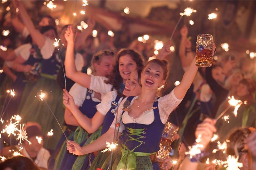 Bedienungen stehen im Hofbräu-Zelt beim traditionellen Kehraus auf den Tischen, halten dabei Wunderkerzen in den Händen und feiern damit das Ende der harten Arbeit auf der Wiesn. 
