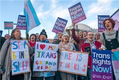 Befürworter des Gesetzes zur Reform der Geschlechteranerkennung protestieren mit Plakaten vor dem Parlament im Vorfeld einer Debatte über den Gesetzentwurf. 
