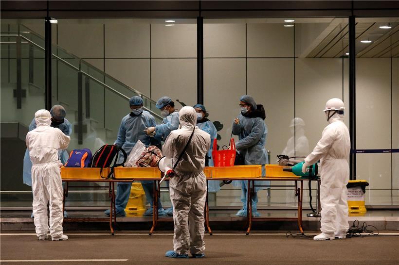 Behördenmitarbeiter untersuchen Flugpassagiere, die aus Wuhan nach Vietnam eingereist sind
