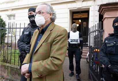 Bei einer Razzia gegen sogenannte „Reichsbürger“ führen vermummte Polizisten, nach der Durchsuchung eines Hauses, Heinrich XIII. Prinz Reuß zu einem Polizeifahrzeug
