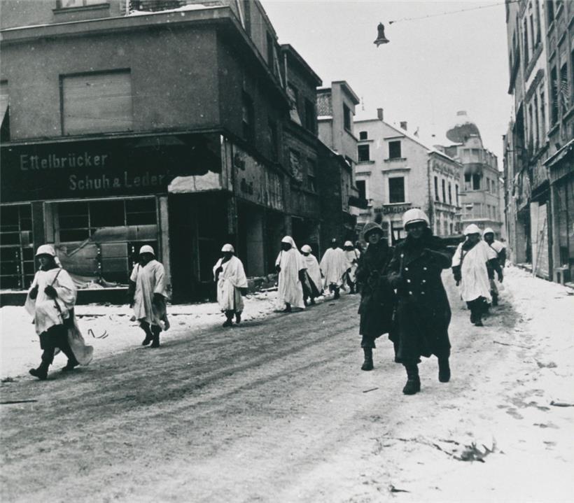 Beim US-amerikanischen Vormarsch durch die am Weihnachtstag 1944 zurückeroberte Stadt Ettelbrück trugen die GIs weiße Tarnungs-Überzüge über ihren Uniformen
