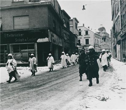 Beim US-amerikanischen Vormarsch durch die am Weihnachtstag 1944 zurückeroberte Stadt Ettelbrück trugen die GIs weiße Tarnungs-Überzüge über ihren Uniformen
