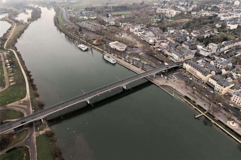 Bereits 1462 wird erstmals eine Brücke über die Mosel bei Remich erwähnt. Die spätere sogenannte alte Brücke wurde 1866 errichtet, jedoch 1944 von der Wehrmacht gesprengt. Daraufhin errichtete die US-Armee eine provisorische Holzbrücke. Die heutige Brücke wurde 1959 gebaut und verbindet die luxemburgische N2 mit der deutschen B406. Sie ist 288,9 Meter lang und sechs…
