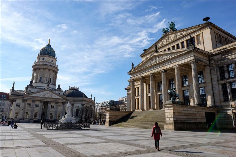 Berlin: Nur wenige Menschen sind auf dem Gendarmenmarkt mit dem Deutschen Dom (l) und dem Schauspielhaus unterwegs. Der Platz ist normalerweise ein beliebter Ort für Touristen. 

