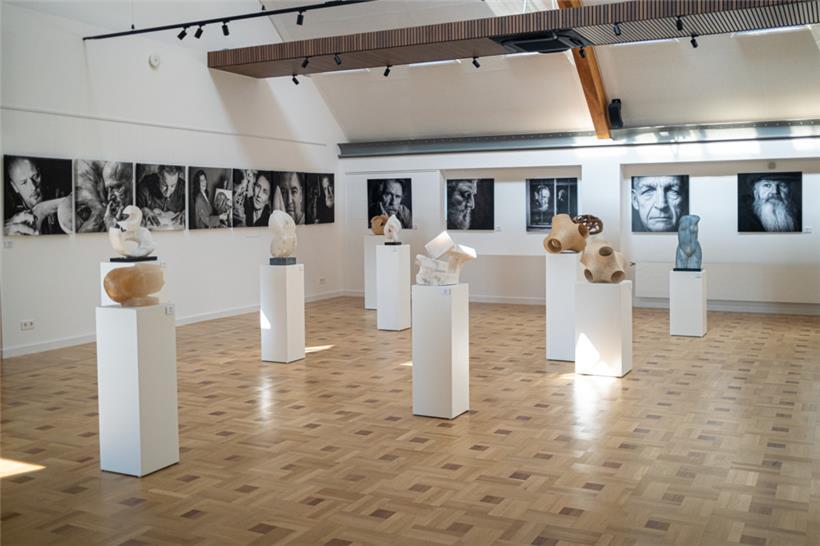 Besuch in der Galerie „A Spiren“: An der Wand hängen Porträts der teilnehmenden Kunstschaffenden von Mars Lépine, die Skulpturen sind von Wouter Van der Vlught und Tom Flick

