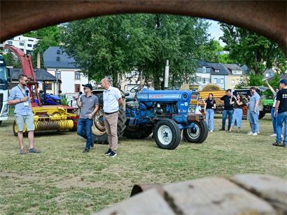 Besucher auf der Foire agricole inspizieren modernen Traktor bei landwirtschaftlicher Messe im Freien