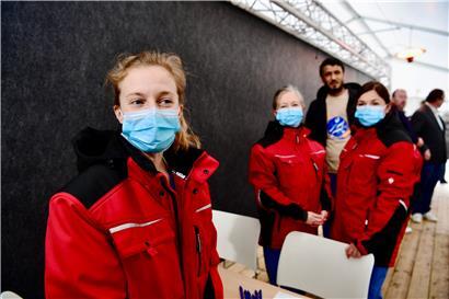 Besucher werden vor dem Eingang vom Krankenhauspersonal gecheckt
