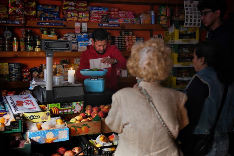Betrieb eines Obstladens in Madrid während des Stromausfalls – mit Kerze und analoger Waage
