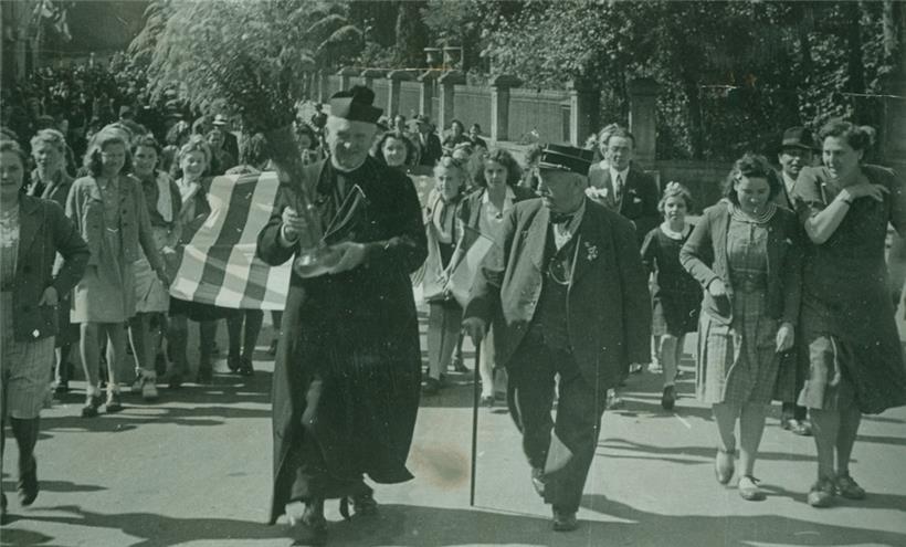 Bettemburger Einwohner, geführt durch Dechant Weirich und Feuerwehr-Veteran Jean Wenner, begrüßen die Befreier
