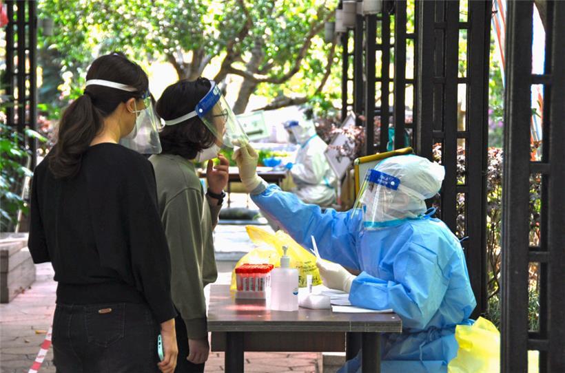 Bewohner einer Wohnanlage unterziehen sich einem PCR-Test, während die Abriegelung aufgrund des Coronavirus in der chinesischen Stadt fortgesetzt wird
