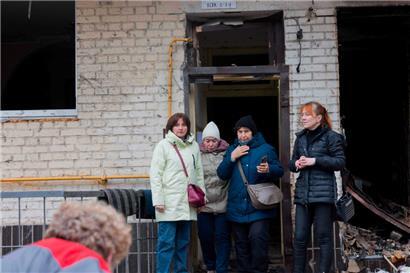 Bewohnerinnen stehen vor ihrem durch einen russischen Drohnenangriff stark beschädigten Wohnhaus in Kiew
