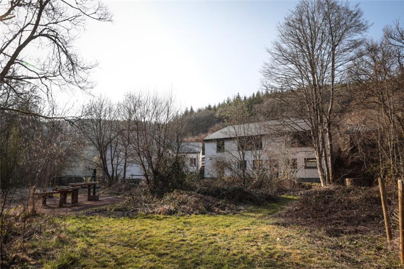 Blick in den Garten: Die über 200 Jahre alte Mühle (Gebäude im Hintergrund) ist seit 1997 im Besitz von „natur & ëmwelt – Fondation Hëllef fir d’Natur“. Seit 2005 wurden die Gebäude mit Hilfe europäischer Gelder renoviert. So ist ein Wassererlebniszentrum (WEZ), die Muschelzuchtstation für Süßwassermuscheln und der Natura 2000 Saal für Workshops und Vorträge…
