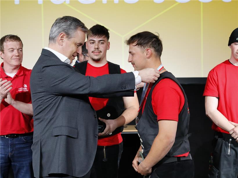Bildungsminister Claude Meisch überreicht feierlich eine Medaille bei offizieller Auszeichnungsszene