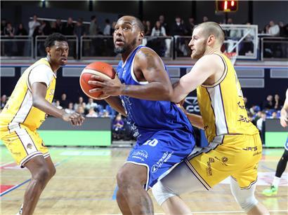 Billy McDaniel bei spannendem Basketballspiel gegen Etzella, entscheidender Korb und jubelnde Spieler