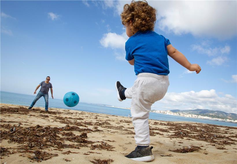 Bis vor wenigen Tagen untersagt: Ein Kind spielt mit seinem Vater Fußball auf einem Strand auf Mallorca 
