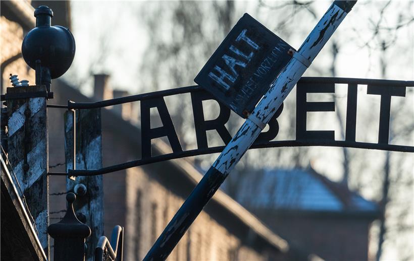 Blick auf das Eingangstor des ehemaligen Konzentrationslagers Auschwitz mit dem Schriftzug „Arbeit macht frei“
