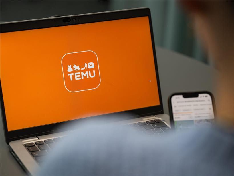 Laptop mit geöffnetem Temu-App-Logo auf dem Bildschirm, moderner Arbeitsplatz mit Fokus auf Online-Shopping-App