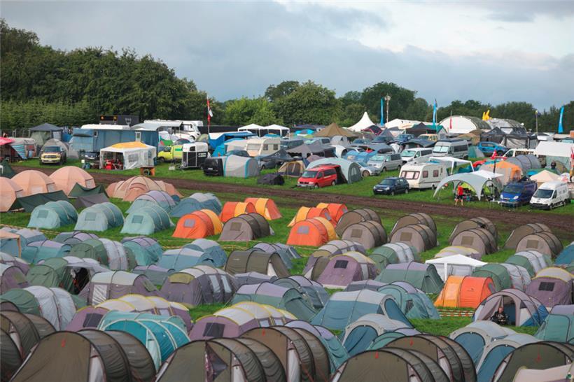 Blick über Zeltplätze auf dem vom Regen aufgeweichten und schlammigen Festivalge...