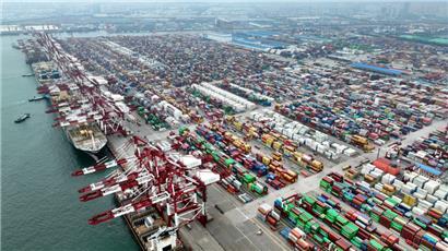 Blick von oben auf ein Containerschiff im Qianwan Container Terminal im Hafen von Qingdao in der ostchinesischen Provinz Shandong. 
