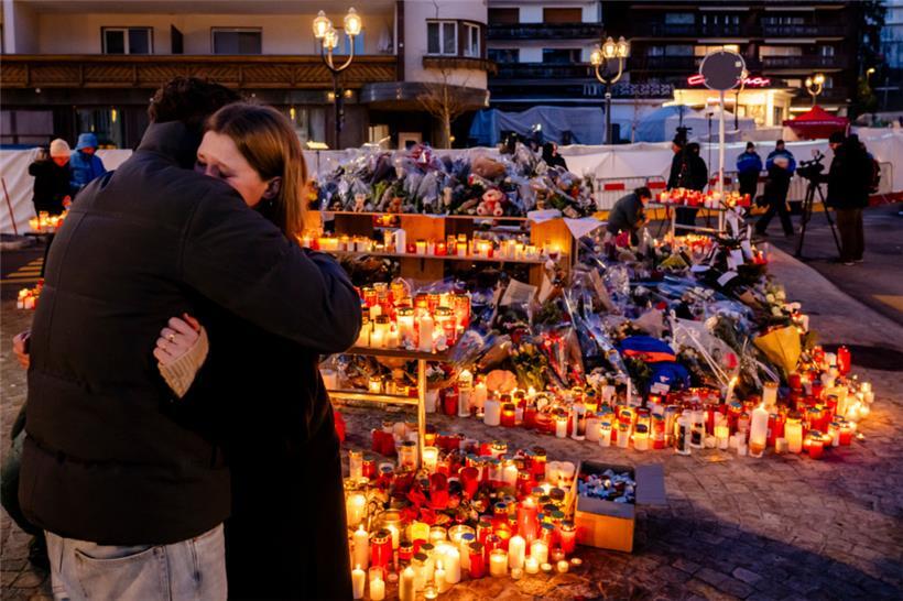 Blumen und Kerzen stehen zum Gedenken an die Opfer des Brandes in der Bar und Lounge „Le Constellation“ in Crans-Montana
