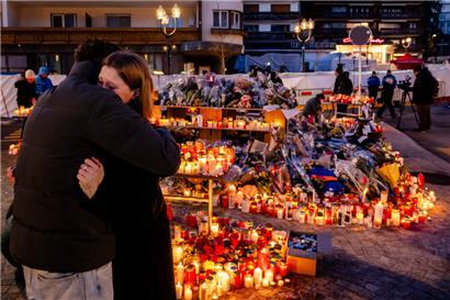Blumen und Kerzen stehen zum Gedenken an die Opfer des Brandes in der Bar und Lounge „Le Constellation“ in Crans-Montana
