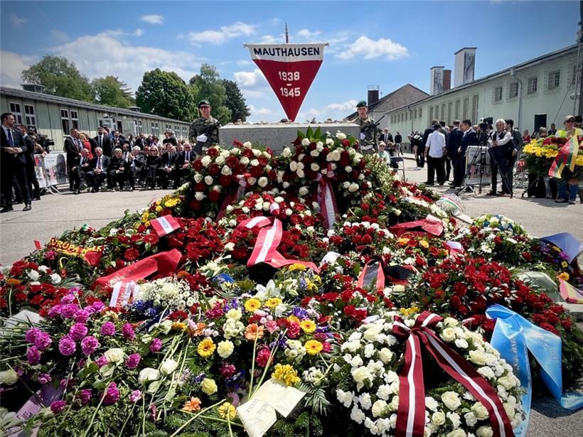 Blumengebinde vor dem zentralen Denkmal auf dem ehemaligen Appellplatz