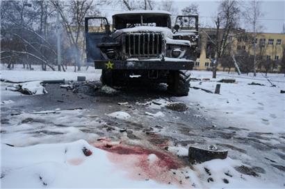 Blut von der Leiche eines Soldaten ist im Schnee neben einem zerstörten russischen Militärfahrzeug mit Mehrfachraketenwerfern am Stadtrand von Charkiw zu sehen
