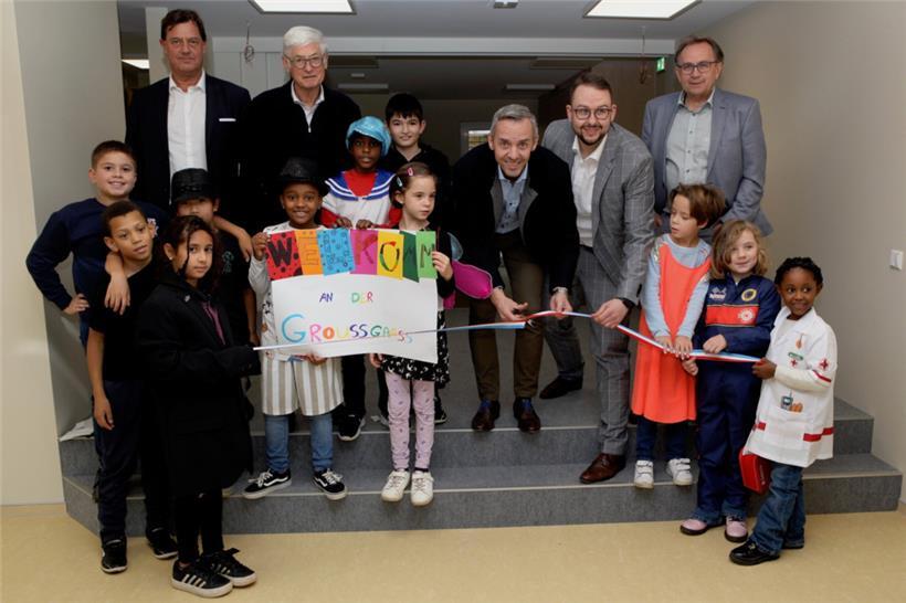 Bürgermeister George Mischo muss sich zum Durchschneiden der Schleife etwas bücken, um auf die Höhe der zukünftigen Schüler der „Maison relais“ zu kommen 
