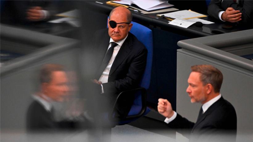 Bundesfinanzminister Christian Lindner bei der Vorstellung seines Haushaltsentwurfs. Im Hintergrund Bundeskanzler Olaf Scholz, der sich beim Joggen eine Verletzung am Auge zuzog.
