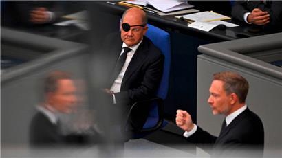 Bundesfinanzminister Christian Lindner bei der Vorstellung seines Haushaltsentwurfs. Im Hintergrund Bundeskanzler Olaf Scholz, der sich beim Joggen eine Verletzung am Auge zuzog.
