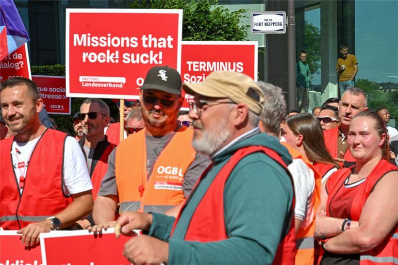 CFL-Mitarbeiter beobachten am Mittwochmorgen im Hauptsitz der Eisenbahngesellschaft die Demonstranten vom OGBL/Landesverband, die sich vor dem Gebäude versammeln
