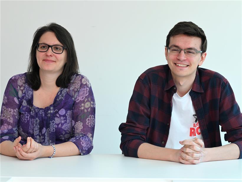 Carole Thoma und André Marques posieren gemeinsam als Co-Sprecher von déi Lénk vor neutralem Hintergrund