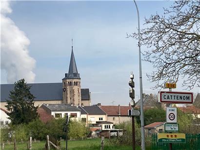 Cattenom hat 2.700 Einwohner. Hinter der Kirche steigt der Dampf einer der Blöcke der Atomzentrale auf.  
