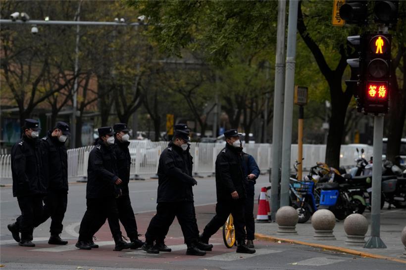 China, Peking: Chinesische Sicherheitskräfte gehen am Montag an einer Kreuzung in der Nähe des Ortes der Proteste vom Vortag vorbei. Aus Angst vor einem Wiederaufflammen der Proteste in China gegen die harte Null-Covid-Strategie der Regierung hat die Polizei ihre Präsenz in mehreren Metropolen massiv verstärkt.
