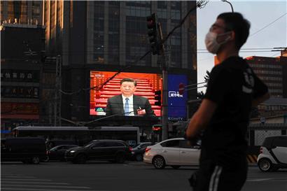 Chinas Präsident Xi Jinping überblickt Pekings Straßen von einer Leinwand aus: Weil die EU keine Sanktionen aussprechen will, gibt es Kritik aus den USA 
