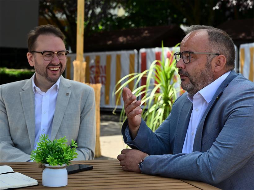 Christian Weis und Carlo Feiereisen lachen bei Gesprächen über Esch, Schifflingen und Anschlussmöglichkeiten zu Lallingen