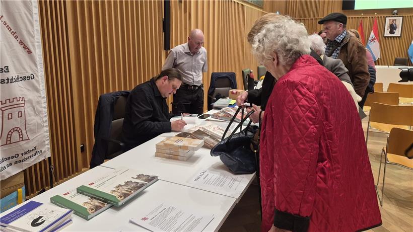 Claude Frentz signiert sein neues Buch bei einer Lesung, Autorenportrait, Buchvorstellung, Buchsignierung