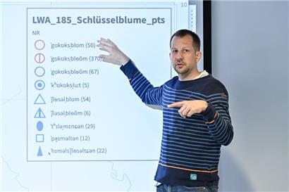 Claude Schmit, der für die Karten im „Wortatlas“ zuständig ist, erläutert am Beispiel der Kuckucksblume den Aufbau des Buches
