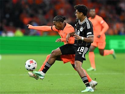 Crysencio Summerville (l., Niederlande) und Nathaniel Brown (Deutschland) kämpfen um den Ball