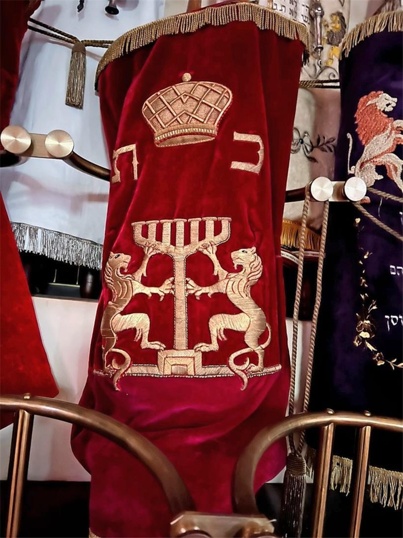 Da Lily als Baby sehr kränkelte, spendete ihr Vater eine Torarolle für die Synagoge. Auf dem Foto sieht man den bestickten und verzierten Mantel, der Lilys Tora beschützt. Lilys Tora befindet sich noch heute in der Heiligen Arche der neuen Synagoge in Luxemburg-Stadt.
