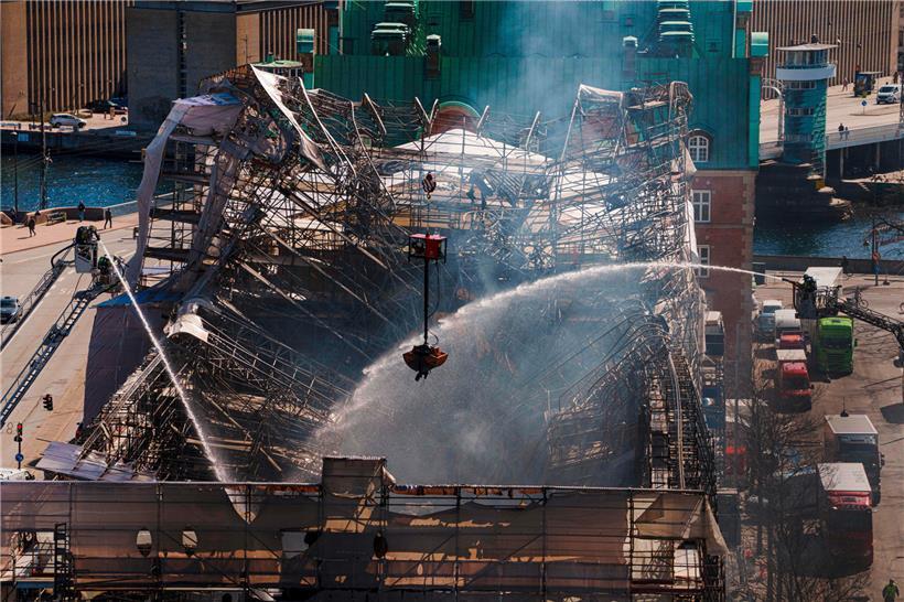 Dänische Feuerwehrleute und Rettungskräfte sind einen Tag nach dem Brand der historischen Börse noch immer mit Löscharbeiten beschäftigt
