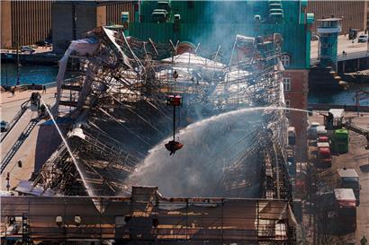 Dänische Feuerwehrleute und Rettungskräfte sind einen Tag nach dem Brand der historischen Börse noch immer mit Löscharbeiten beschäftigt
