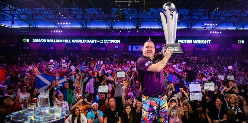 Dartspieler Peter Wright (Schottland) jubelt nach seinem Sieg und hebt die Sid-Waddell-Trophäe in die Luft
